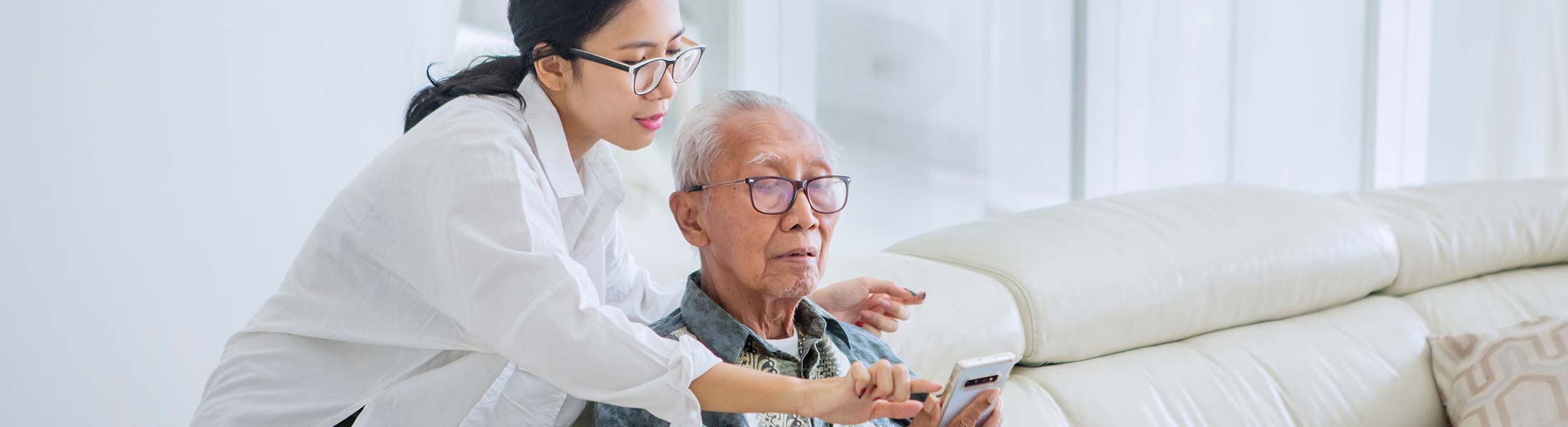image of caregiver helping elderly person with smartphone