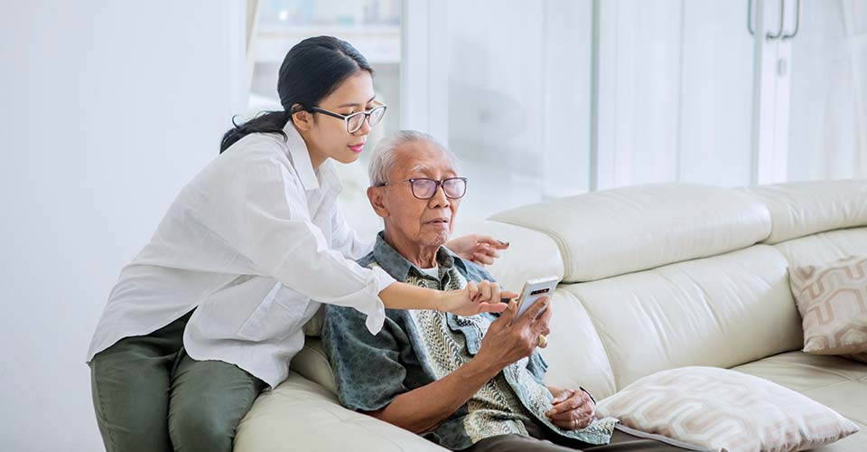image of caregiver helping elderly person with smartphone